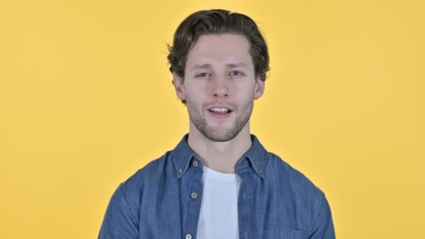 Pozitivní mladý muž tleskání a jásot na žlutém pozadí — Stock video