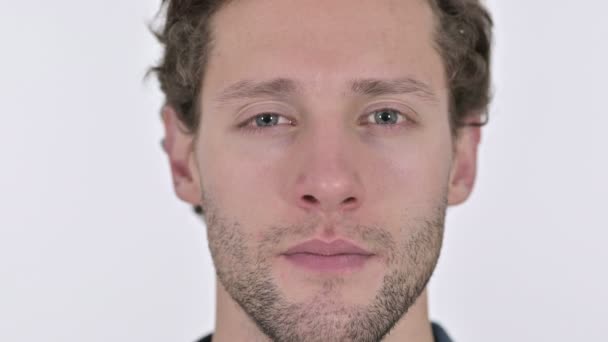Close-up van glimlachende jonge man gezicht op witte achtergrond — Stockvideo