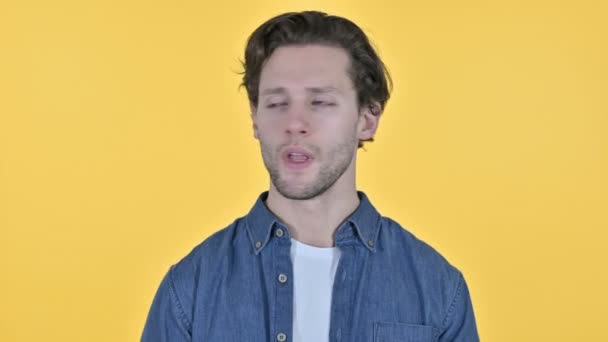 Portrét nemocného mladého muže kašlání na žlutém pozadí — Stock video