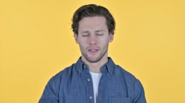 Başı ağrıyan genç adam, sarı arka planda baş ağrısı