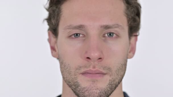 Nahaufnahme eines ernsten jungen Mannes Gesicht auf weißem Hintergrund — Stockvideo