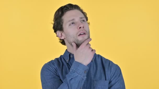 Contemplative Young Man Thinking New Idea on Yellow Background — Stock Video