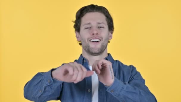 Joven alegre bailando música sobre fondo amarillo — Vídeos de Stock