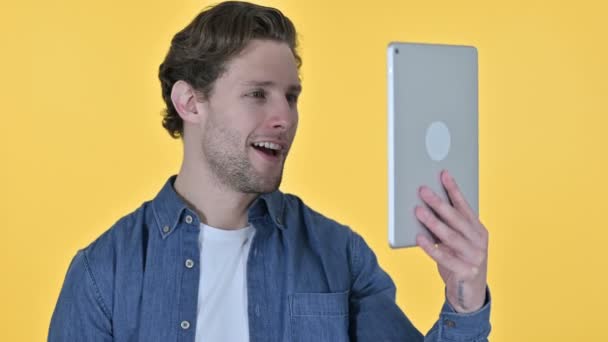 Chat de vídeo en línea en la tableta por el hombre joven sobre fondo amarillo — Vídeo de stock