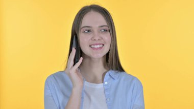 Sıradan Genç Kadın Akıllı Telefonla Konuşuyor, Sarı Arkaplan