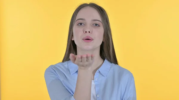 Létající polibek podle ležérní mladá žena, žluté pozadí — Stock fotografie