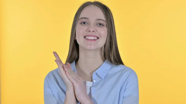 Vidám alkalmi fiatal nő tapsol, sárga háttér — Stock Fotó