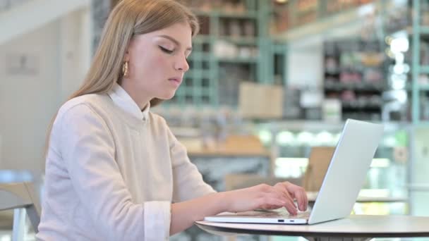 Szokujące wyrażenie przez młodą kobietę za pomocą laptopa w Cafe — Wideo stockowe