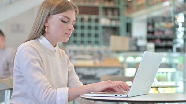 Laptop uso por mulher jovem sorrindo para a câmera no café — Vídeo de Stock