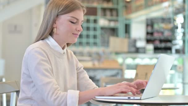 在咖啡店的笔记本电脑上工作的年轻妇女 — 图库视频影像