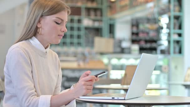 Unga kvinna pratar på Smartphone i Café — Stockvideo