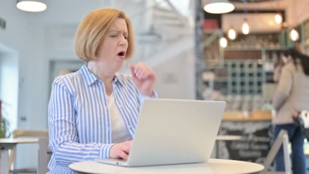 Cafe 'de dizüstü bilgisayar öksürüğü kullanan yaratıcı yaşlı kadın — Stok video