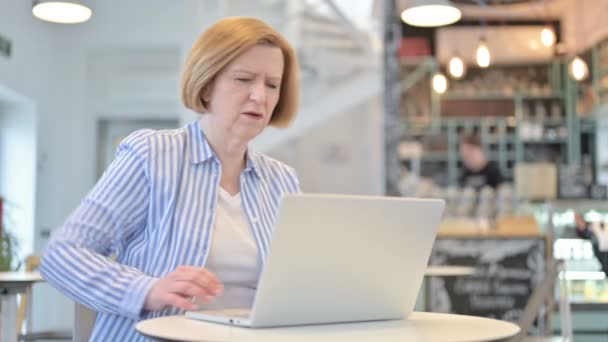 Kreatywna stara kobieta z bólem pleców za pomocą laptopa w Cafe — Wideo stockowe