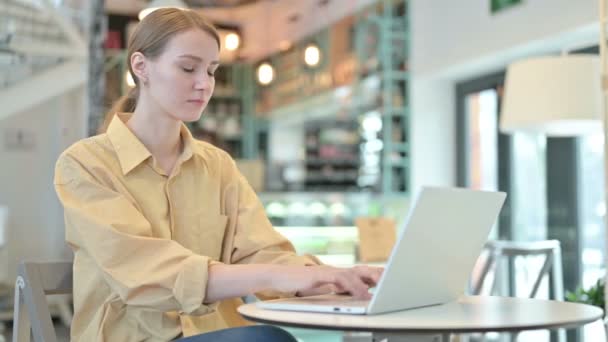 Hustende junge Frau benutzt Laptop im Cafe — Stockvideo