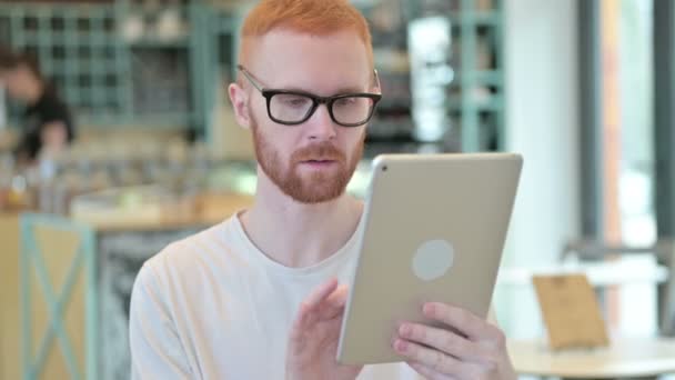 Portret Rudego mężczyzny świętującego sukces na tablecie cyfrowym — Wideo stockowe