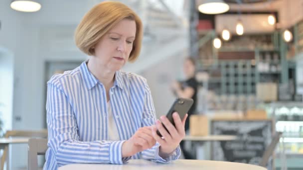 카페에서 나이든 창의적 인 여성 이 스마트폰을 사용하는 모습 — 비디오