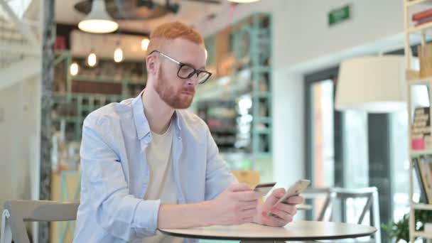 Online Betalning framgång på telefon av Redhead Man i Cafe — Stockvideo