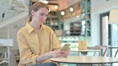 Kafe 'de akıllı telefon kullanan Ciddi Genç Kadın
