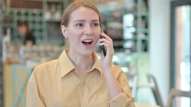 Egy fiatal nő portréja, aki okostelefonon beszél. — Stock videók