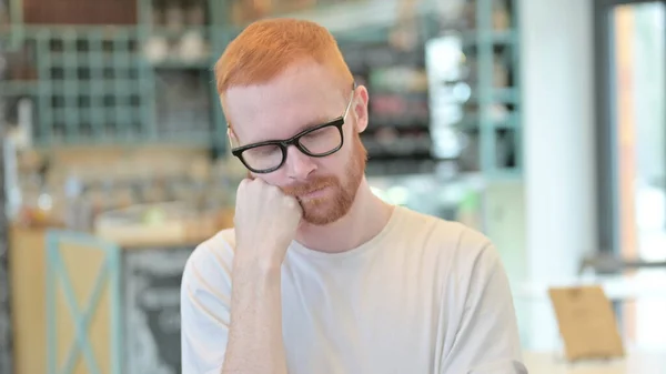 Portret van uitgeputte roodharige man die een dutje neemt — Stockfoto