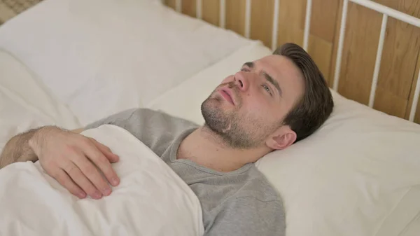 Upset Young Man Thinking in Bed — Stockfoto