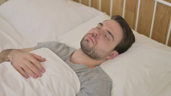 Joven cansado durmiendo la siesta en la cama — Foto de Stock