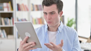 Young Man Upset by Loss on Tablet