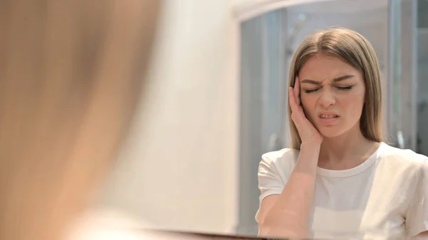 Woman Looking in Mirror and having Headache — стокове фото