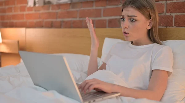 Dühös fiatal nő reagál veszteséget Laptop az ágyban — Stock Fotó