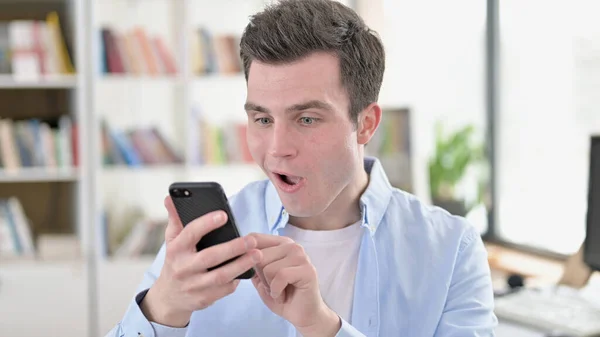 Excited Young Man Amazed by News on Smartphone — Stock Photo, Image