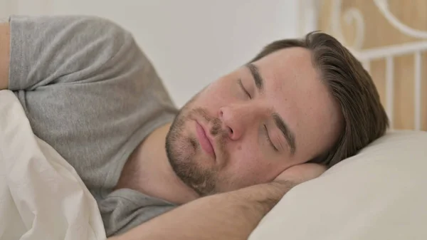 Porträt eines jungen Mannes, der im Bett schläft — Stockfoto