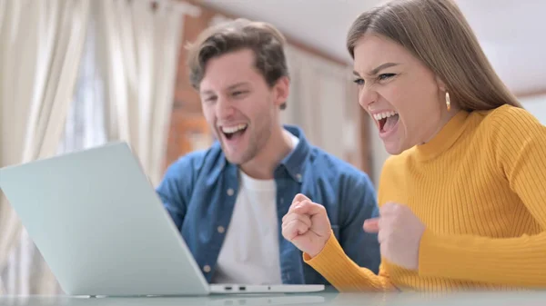 Pareja joven celebrando el éxito en el ordenador portátil — Foto de Stock