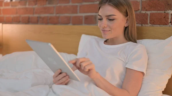 Mulher nova usando Tablet na cama — Fotografia de Stock