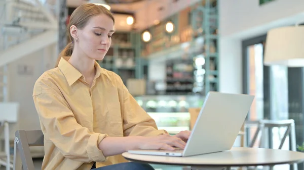 Professionale giovane donna che utilizza il computer portatile in Cafe — Foto Stock