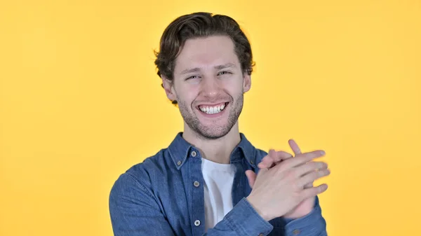 Positieve jonge man klappen en juichen op gele achtergrond — Stockfoto