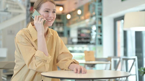 Allegro giovane donna che parla su Smartphone in Cafe — Foto Stock