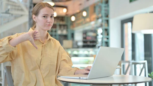 年轻女子在咖啡店用手提电脑把拇指按下 — 图库照片
