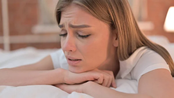 Sad Young Woman Crying in Bed