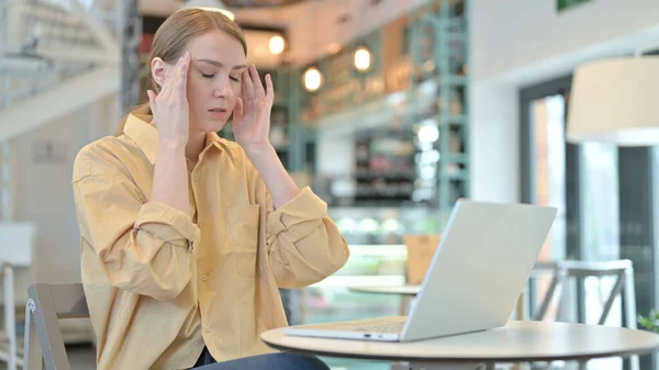 Młoda kobieta z bólem głowy za pomocą laptopa w Cafe — Zdjęcie stockowe