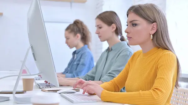 Équipe féminine créative travaillant sur bureau et ordinateur portable — Photo