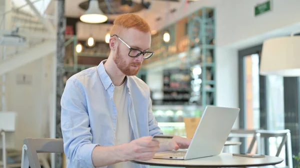 Online winkelen door Redhead Man in Cafe — Stockfoto