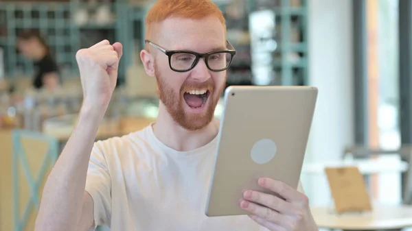 Homme rousse célébrant le succès sur tablette — Photo