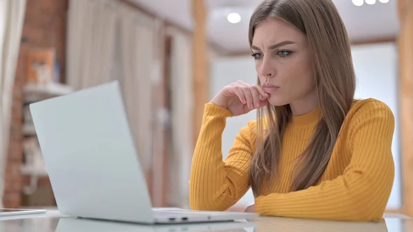 Hermosa mujer joven pensando y trabajando en el ordenador portátil — Foto de Stock