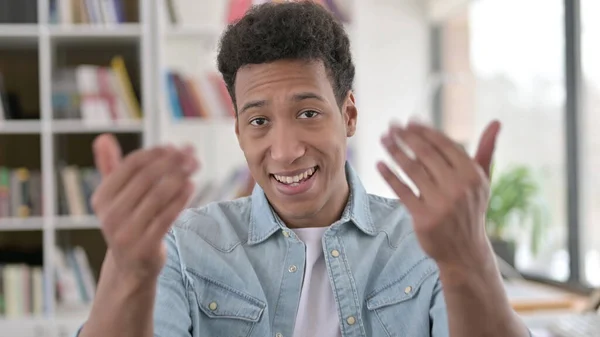 Begrüßt junge afrikanisch-amerikanische Mann zeigt in die Kamera, einladend — Stockfoto