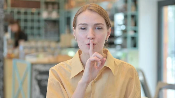 Ritratto di giovane donna che mette il dito sulle labbra, segno silenzioso — Foto Stock