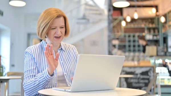 Video Chat sul computer portatile da Creative Old Woman in Cafe — Foto Stock