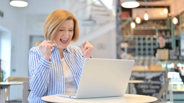 Vecchia donna creativa che festeggia sul computer portatile nel caffè — Foto Stock