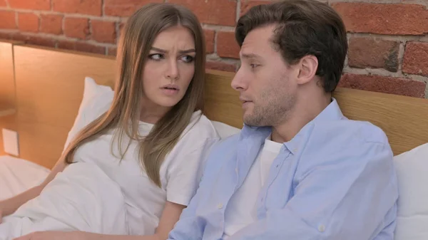 Schönes junges Paar diskutiert im Bett — Stockfoto