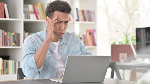 Gestreste jonge Afro-Amerikaanse man met hoofdpijn op het werk — Stockfoto