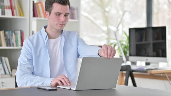 Junger Mann öffnet Laptop für die Arbeit — Stockfoto